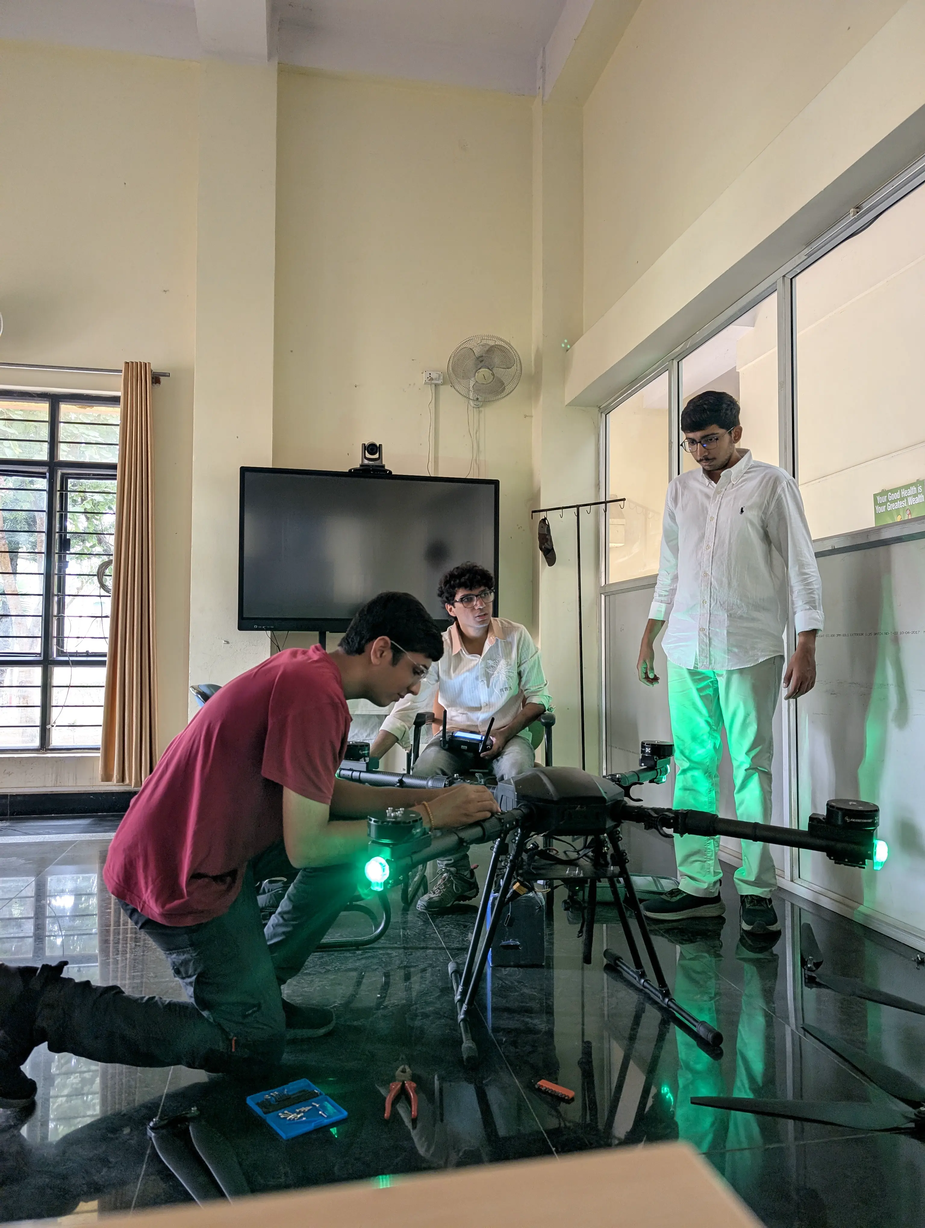 Engineers working on a large quadcopter during maintenance and repair at an Army base