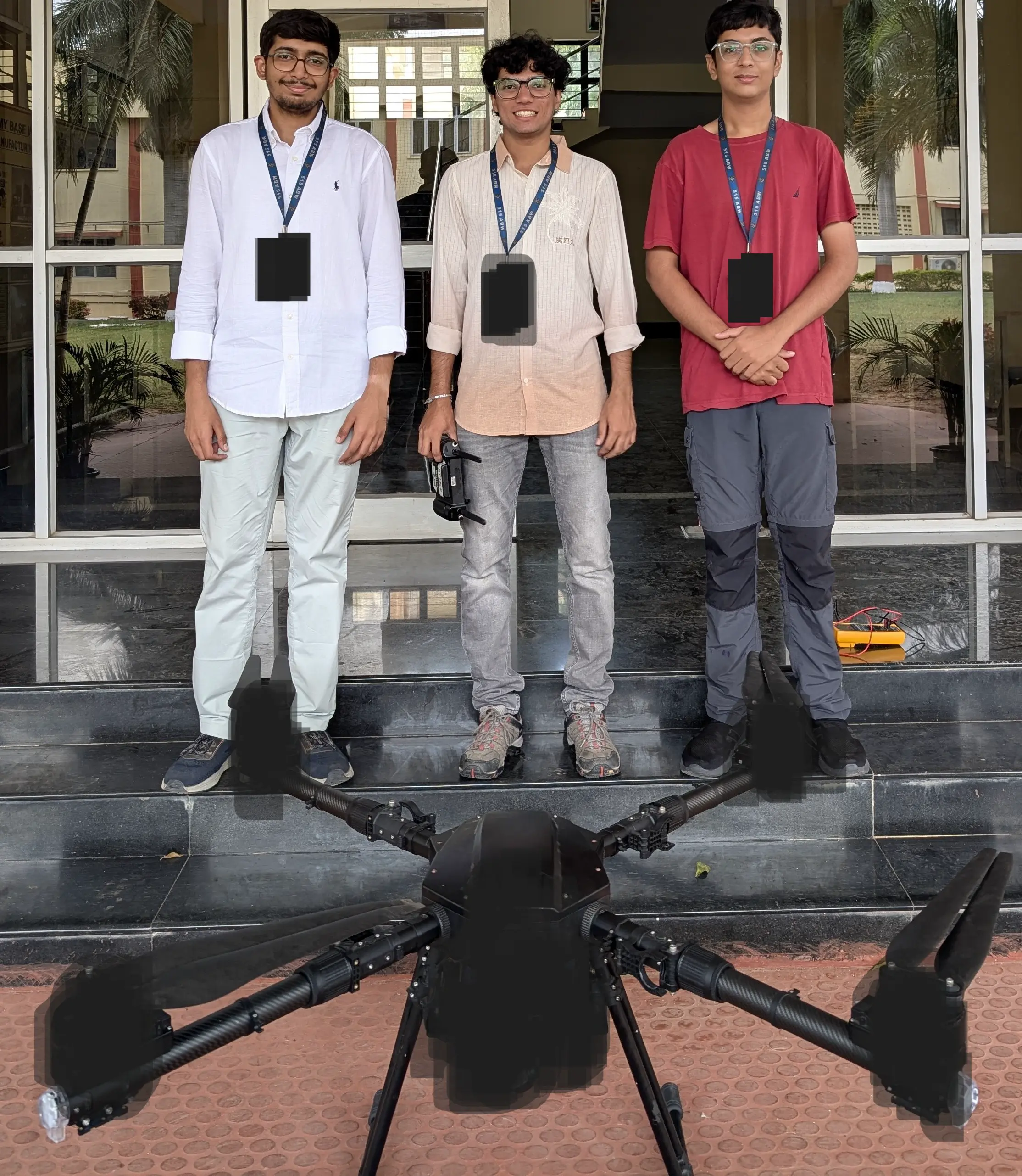 Three engineers standing with a large defence-grade quadcopter at an Army base in Bengaluru